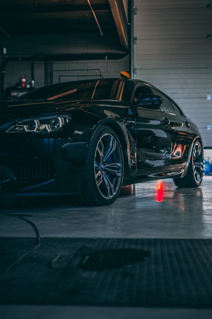 a black car parked in a garage for a detail.